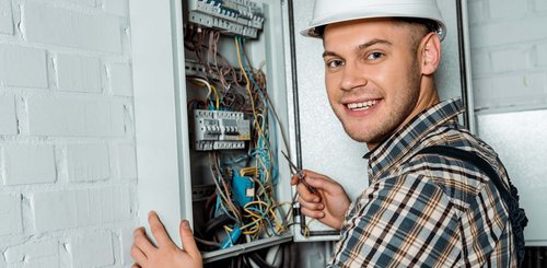 EIn Elektroniker der an einem Verteilerkasten arbeitet