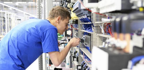 Ein Elektroniker der an einem Verteilerkasten arbeitet