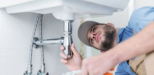 Ein Monteur unter einem Waschbecken