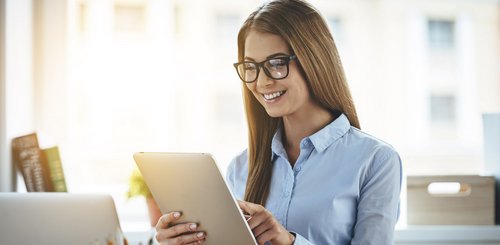 Eine Buerofrau die ein Tablet bedient
